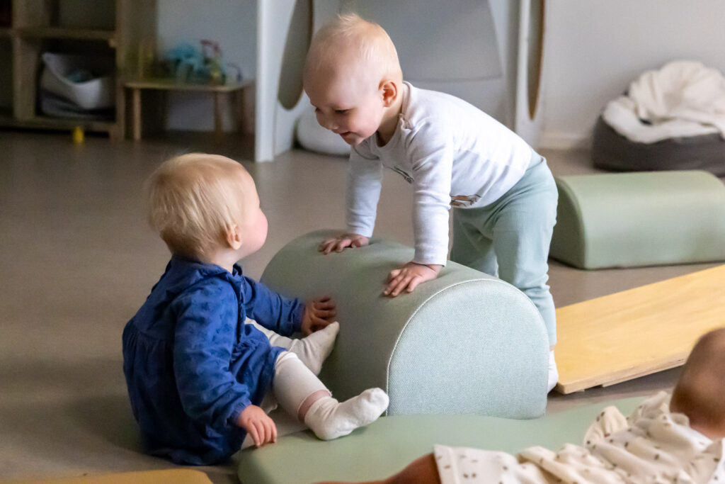 Twee kleine kinderen kijken lachend naar elkaar